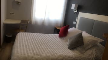 Une chambre à coucher avec un lit, un bureau et une chaise.