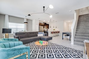 A modern living room with a sectional sofa, a coffee table, and a patterned rug.