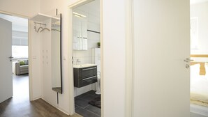 A modern bathroom with a large mirror, a toilet, and a sink. - Wohnung Heinrichstraße 8 (Norderney)