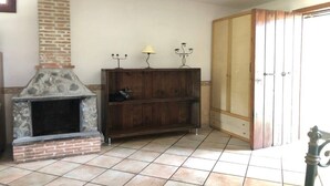 Um quarto com lareira de pedra, estantes de madeira e um guarda-roupa de madeira grande.