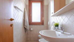 Ein Badezimmer mit Waschbecken, Toilette und Duschbereich.