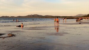 Una spiaggia con persone che si rilassano e giocano.