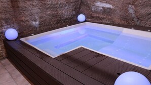 A hot tub with a wooden deck and two spherical light fixtures. - "Casa Rural La Cuca" (Lerín)