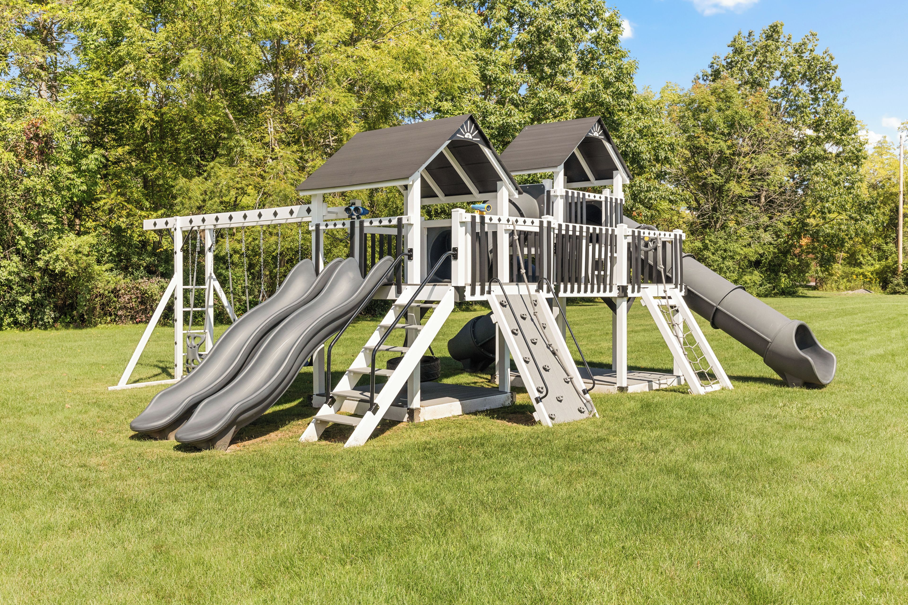 A playground with two slides and a climbing structure.