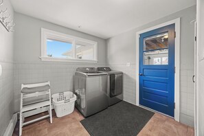 A laundry room with a washing machine, dryer, and a drying rack. - Wide Open Views: lakefront home with hot tub (Geneva)