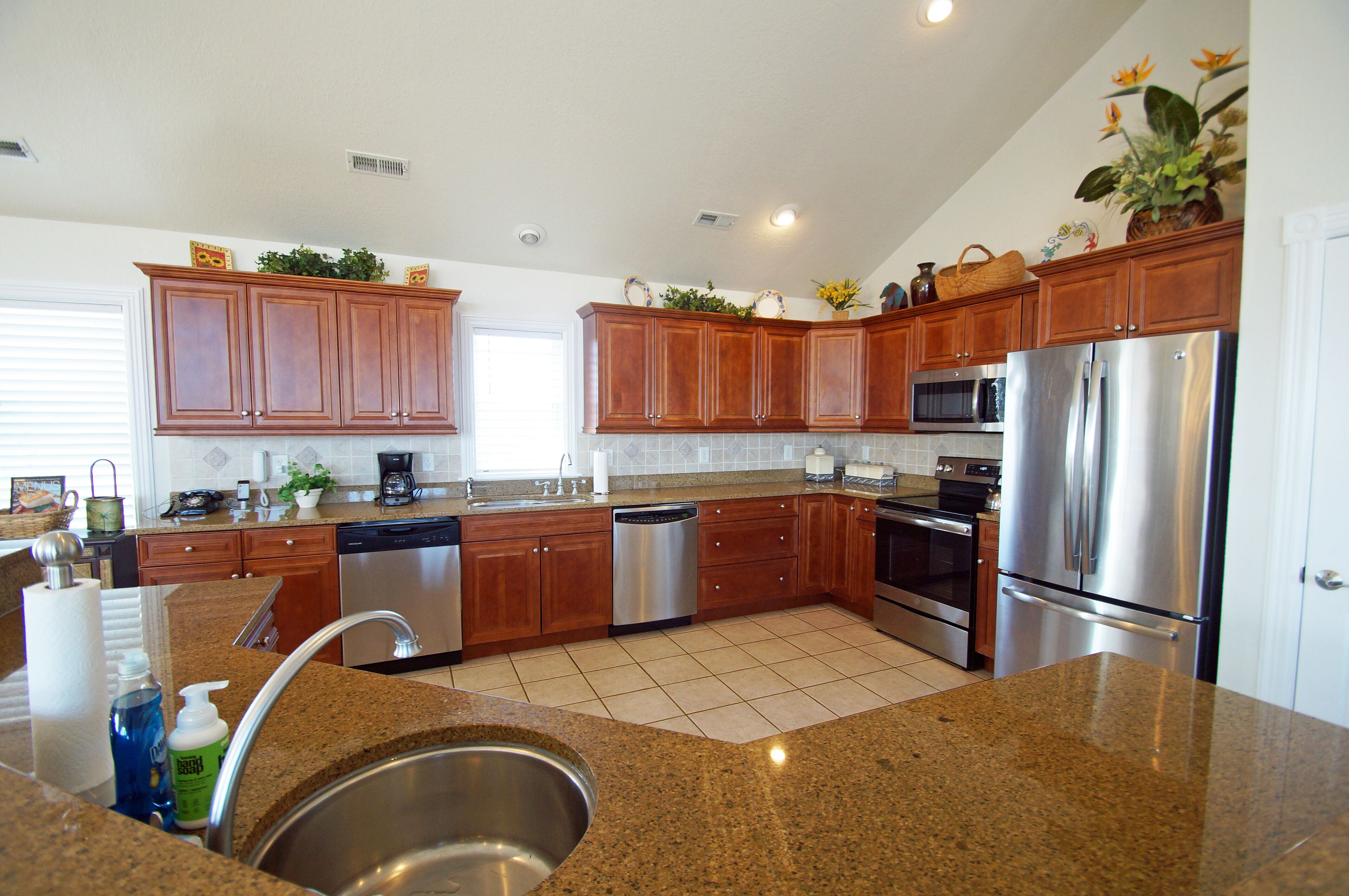 A modern kitchen with granite countertops, stainless steel appliances, and wooden cabinets.