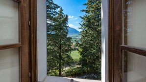 A view through an open window with wooden frames, overlooking a landscape with trees and a distant mountain. - Borgo Colle Ridente 13, Emma Villas (Camerino)