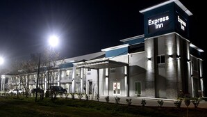 A modern hotel with a prominent Express Inn sign, covered parking, and a well-lit entrance.