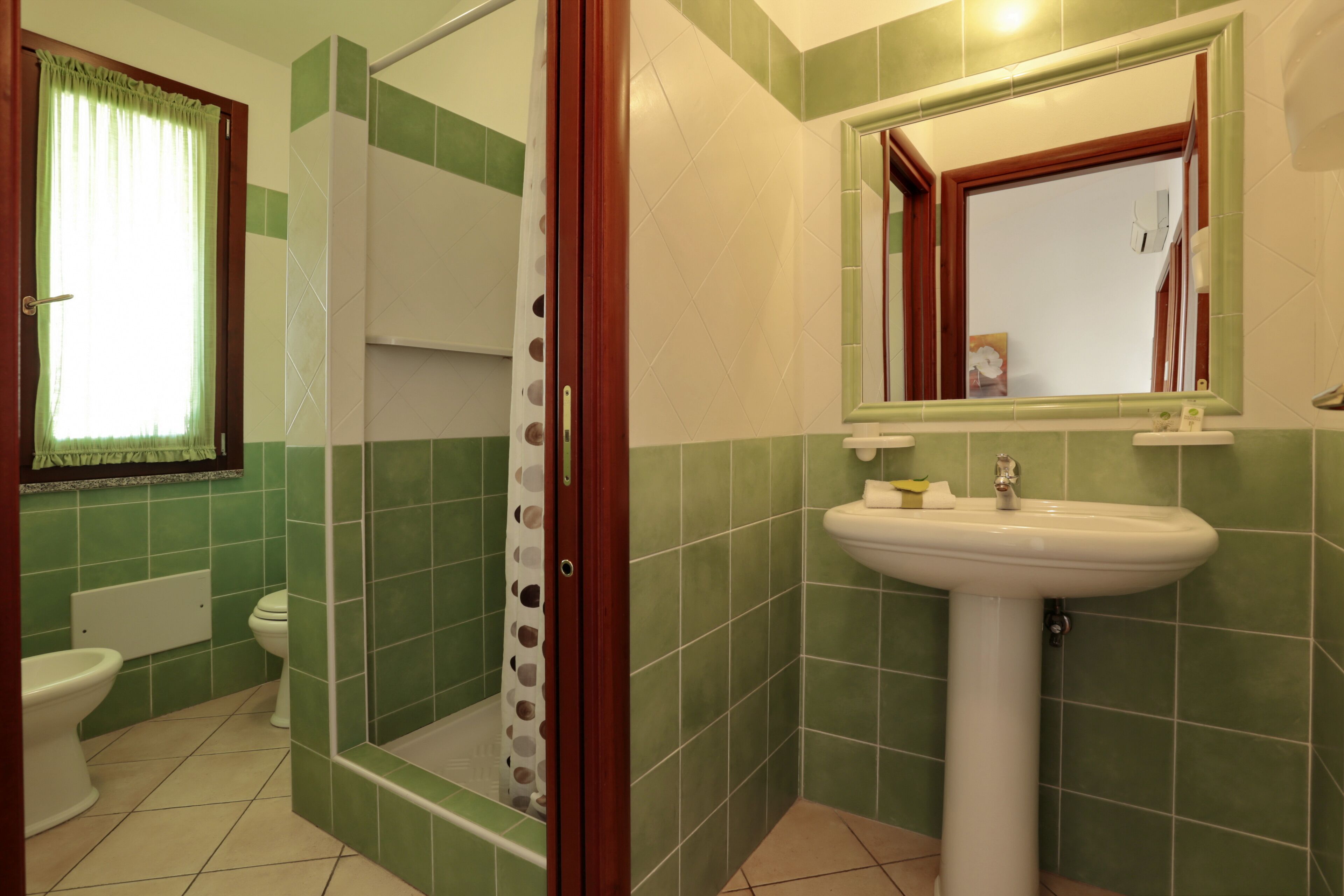 A bathroom with a shower, toilet, and sink.