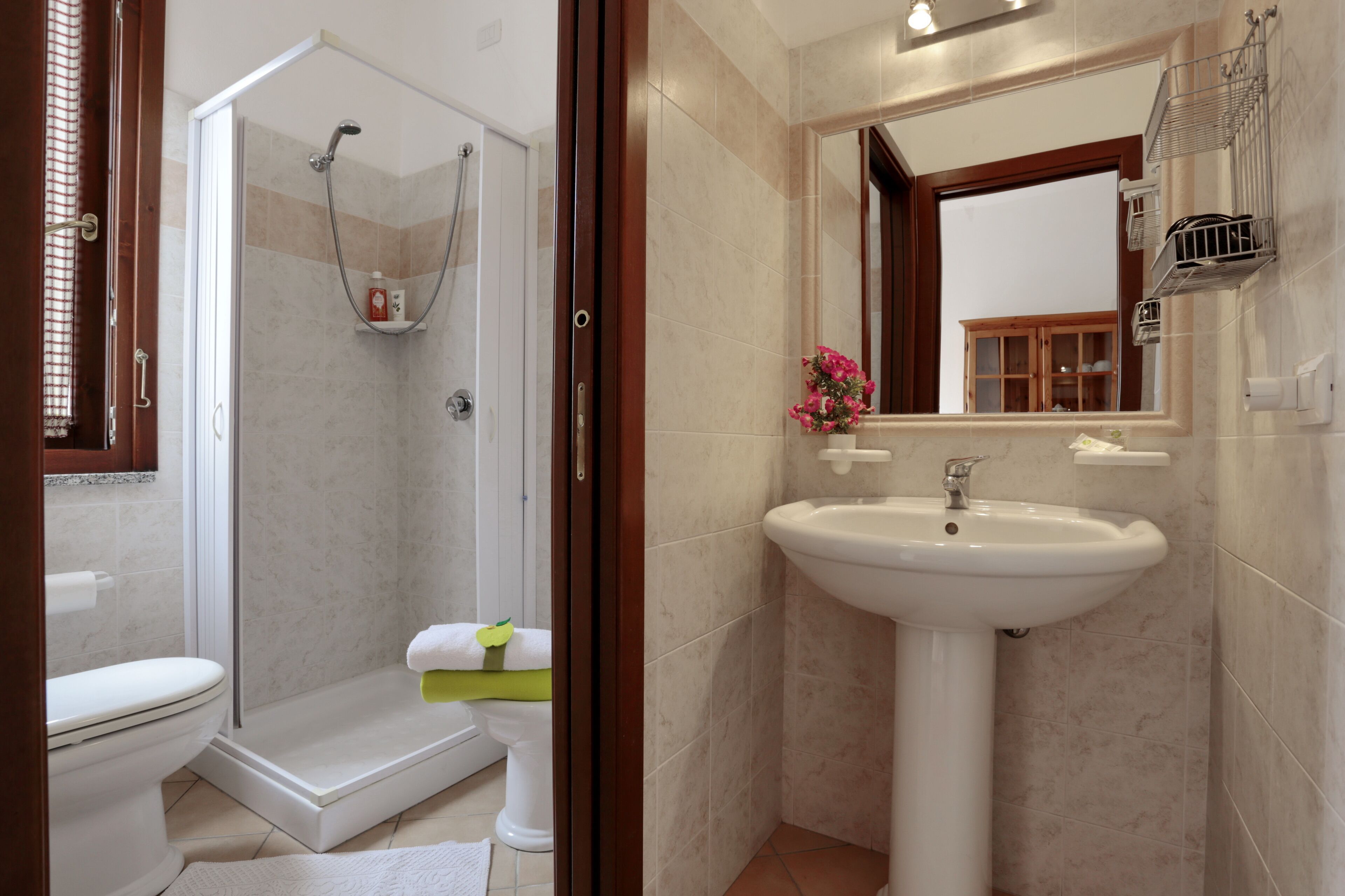 Baño con ducha, inodoro, lavabo y espejo.