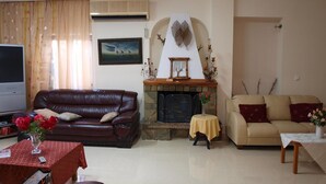 A living room with a fireplace, two sofas, a TV, and a coffee table. - Hotel Pyrgos (Chania)