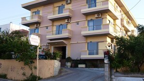 A multi-story hotel with balconies, a sign indicating it is a hotel, and a gated entrance. - Hotel Pyrgos (Chania)