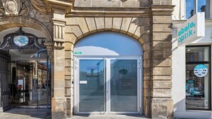 Een gebouwdeur met glazen toegang, een bord met 'Netzabging Institut' en een aanduiding 'Maximilianplatz 6'.