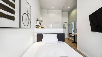 Ett modernt hotellrum med en stor säng, ett skrivbord och en tv.