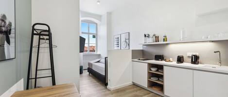A modern kitchen with white cabinets, a wooden table, and a built-in sink.