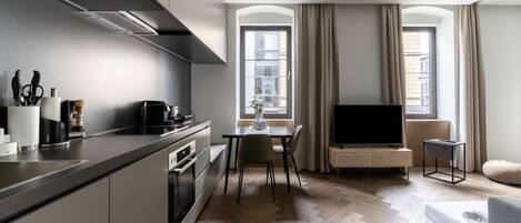 Una cocina moderna con comedor, televisor de pantalla plana y sofá.