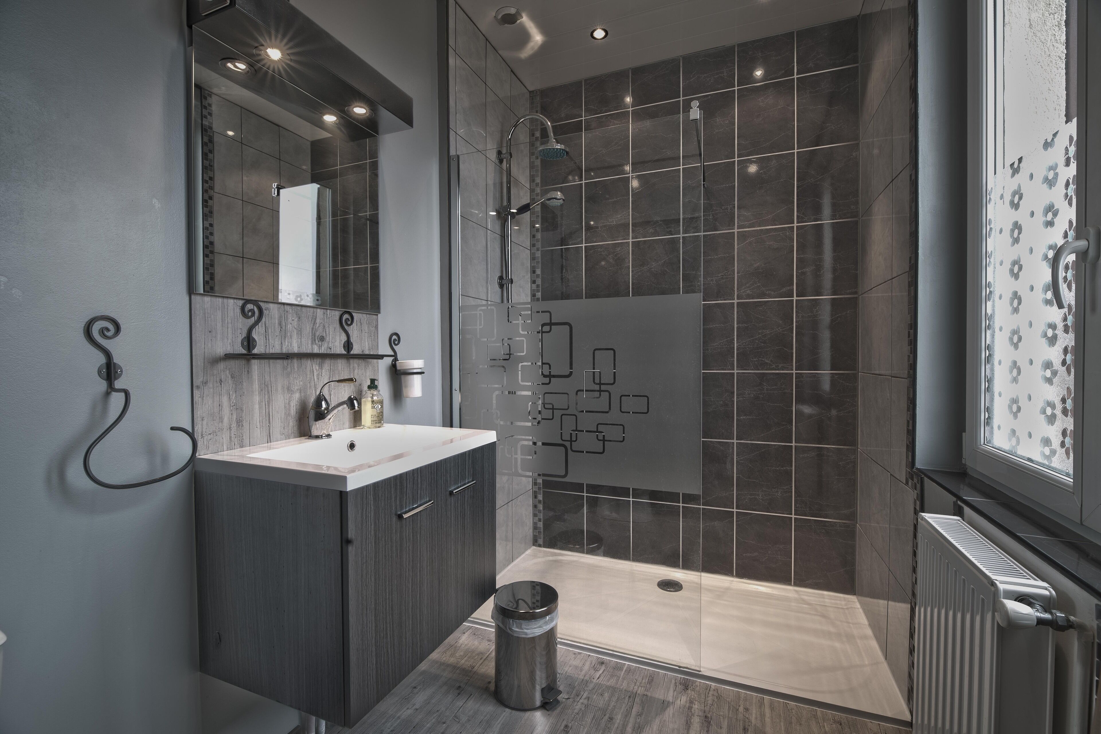 A modern bathroom with a shower, a sink, and a toilet.