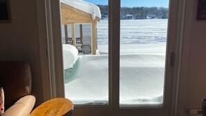 A room with a sliding glass door leading to a snowy outdoor area.
