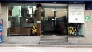 The exterior of Hotel Noratan Palace with a clear entrance, a bench outside, and a welcome sign. - ADB Rooms Hotel Noratan Palace (New Delhi)