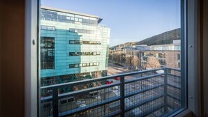 A modern building with a glass facade and a metal balcony railing. - Contemporary Holyrood Apartment (Edinburgh)
