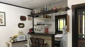 A kitchen with a dining area, featuring a microwave, a coffee maker, and a refrigerator. - House located 200 m from the beach, leisure area, restaurants, bars and shops (Mata de São João)