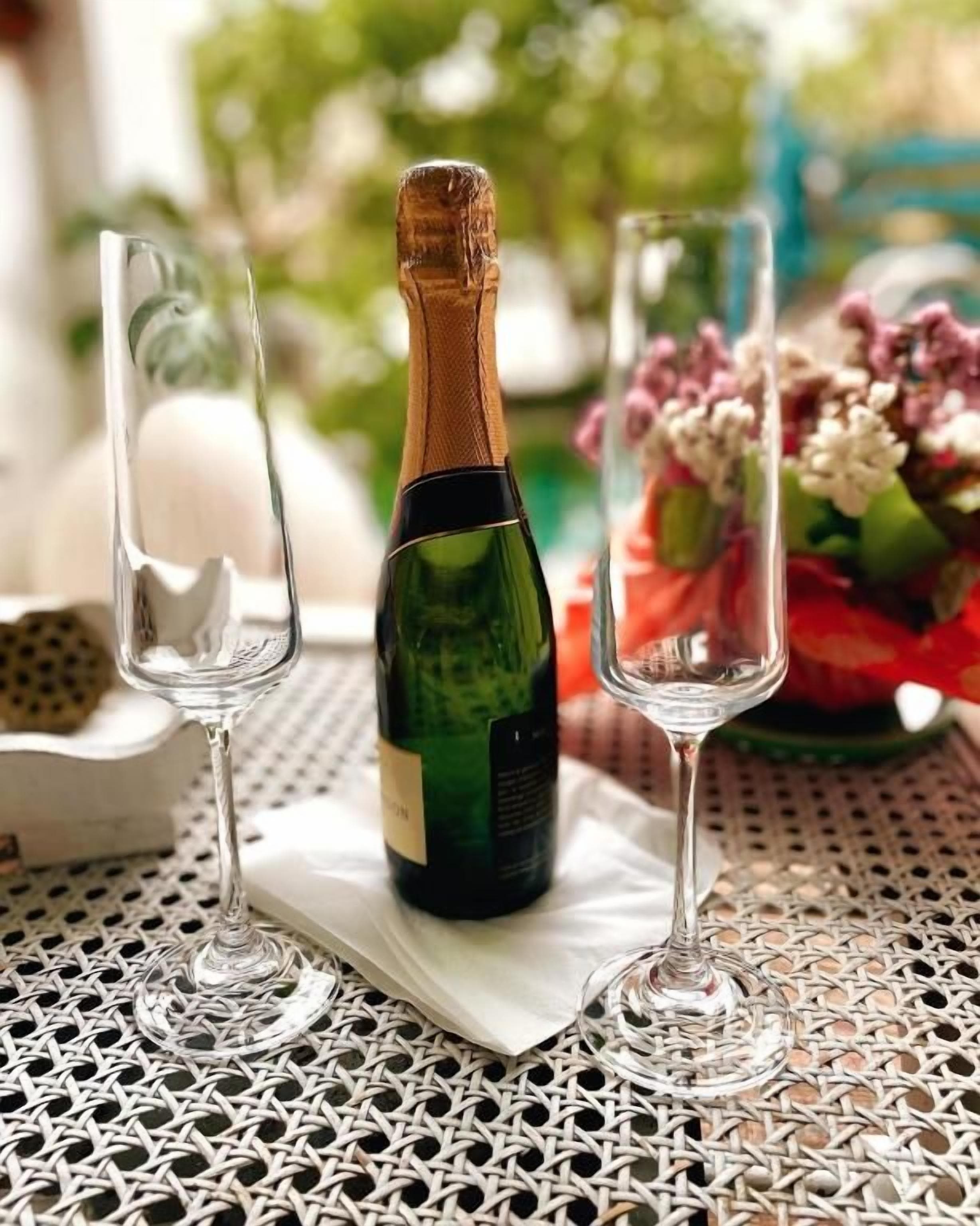 Una bottiglia di champagne su un tavolo con due calici.