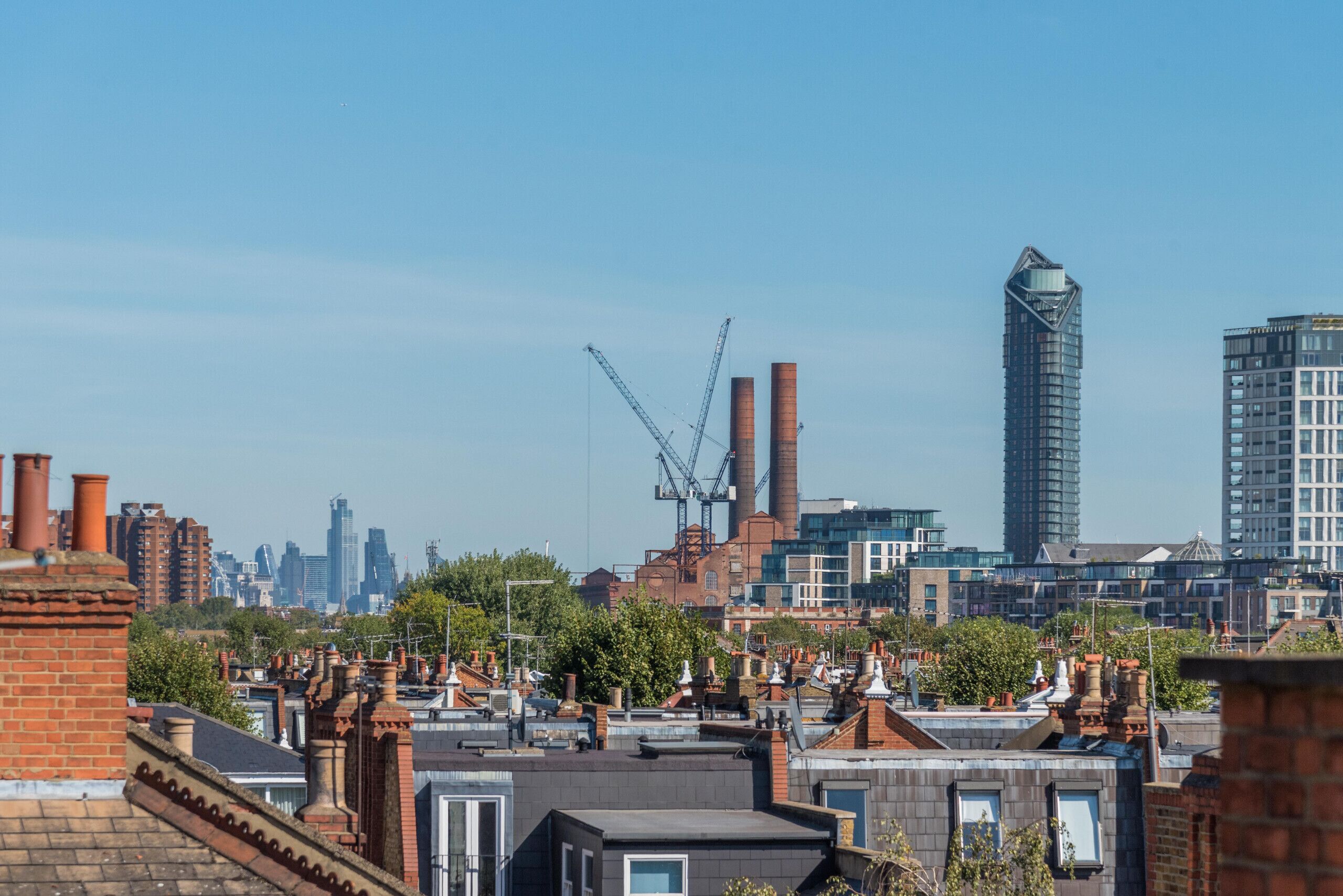 A cityscape with a mix of residential and commercial buildings, including a prominent tall building and industrial structures.