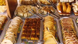 A buffet with various dishes including sandwiches, salads, and desserts. - Peruibe Suites Flat (Peruíbe)