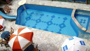 A swimming pool with a blue tiled floor and a mural depicting marine life on the wall. - Peruibe Suites Flat (Peruíbe)