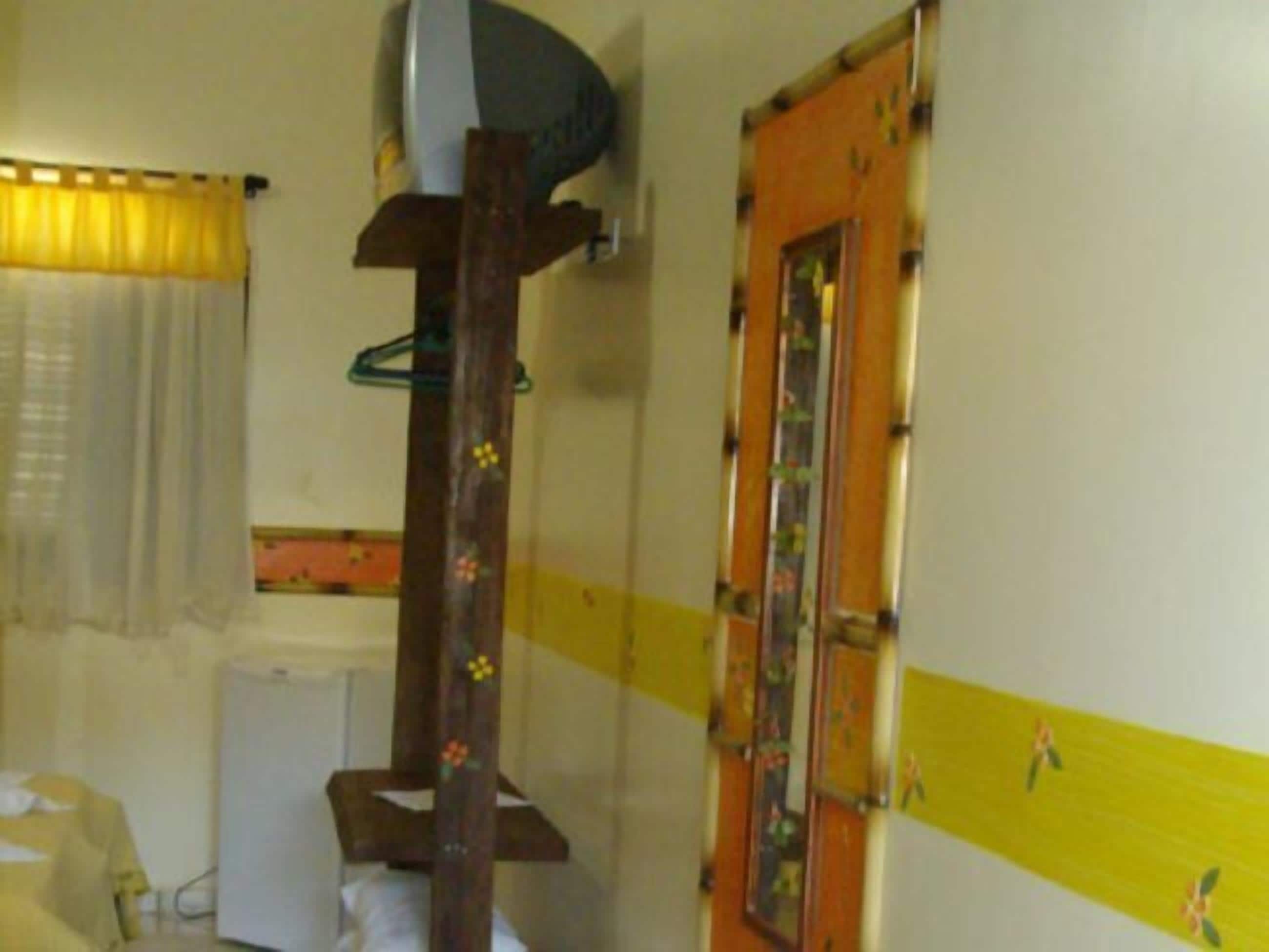 A bathroom with a wooden structure, a mirror, and a yellow-striped wall.