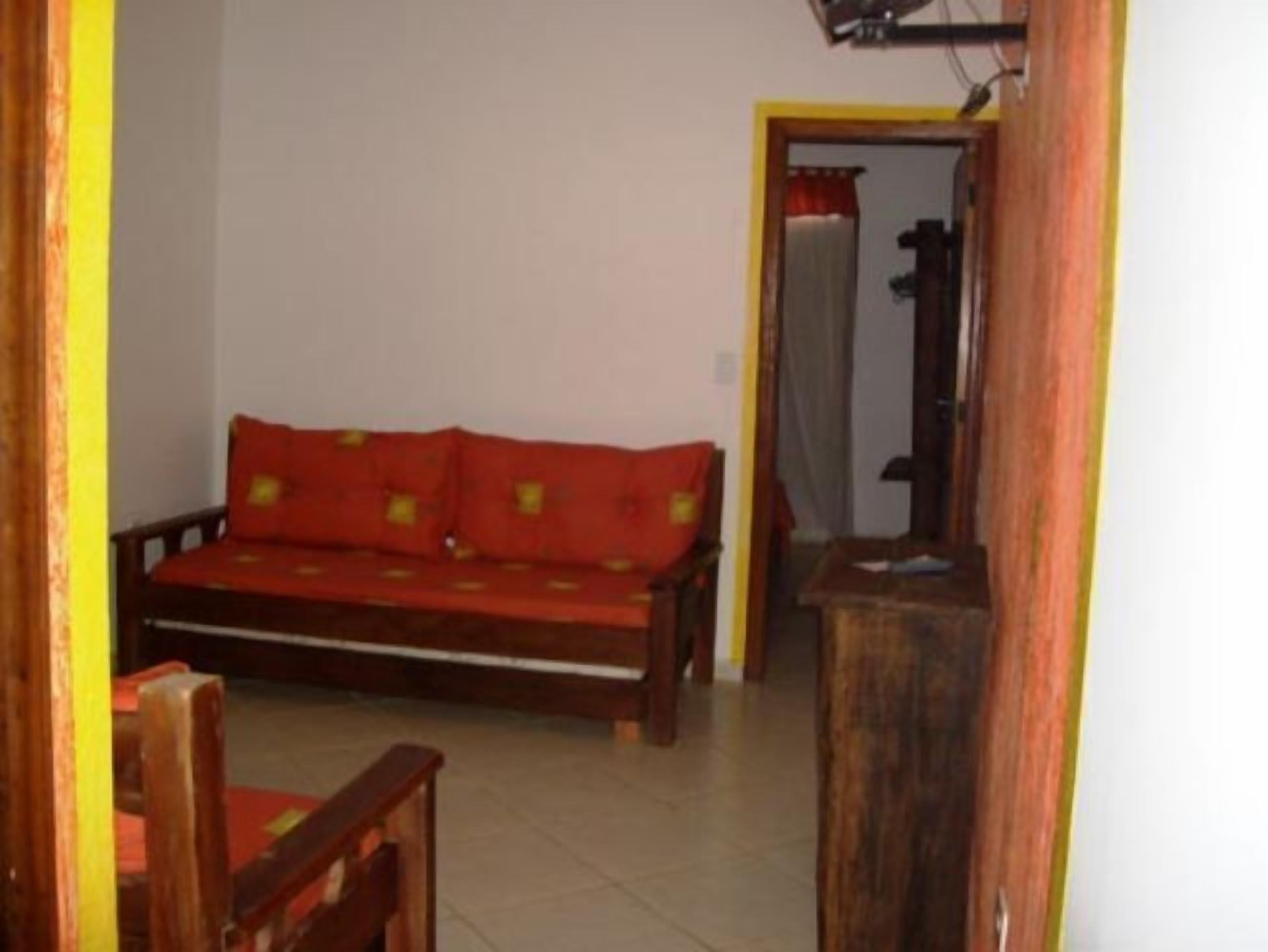 A room with a wooden sofa and a wooden chair.
