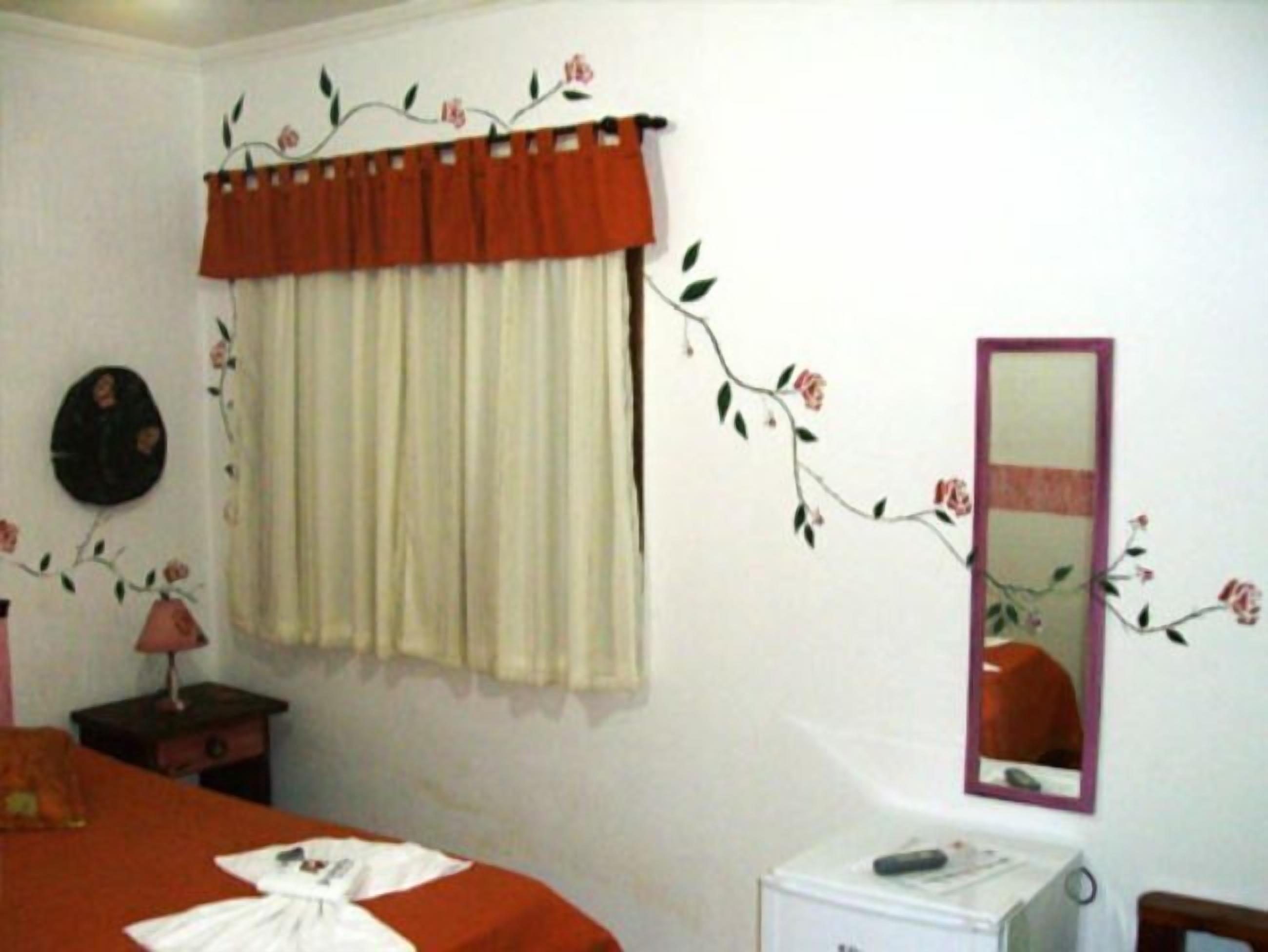Une chambre à coucher comprenant un lit, une table de chevet, un miroir et un radiateur fixé au mur.