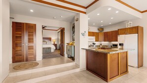Una cocina moderna con armarios de madera, una isla central y un refrigerador.