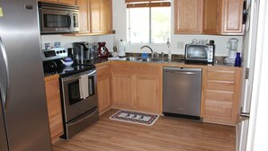 Una cocina con armarios de madera, electrodomésticos de acero inoxidable y una ventana.