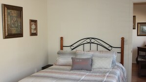 Una cama bien hecha con ropa de cama a rayas y una almohada con la inscripci ón 'Life is beautiful'.