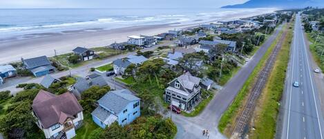 Vista aérea de una zona residencial costera con casas, una playa y una carretera.