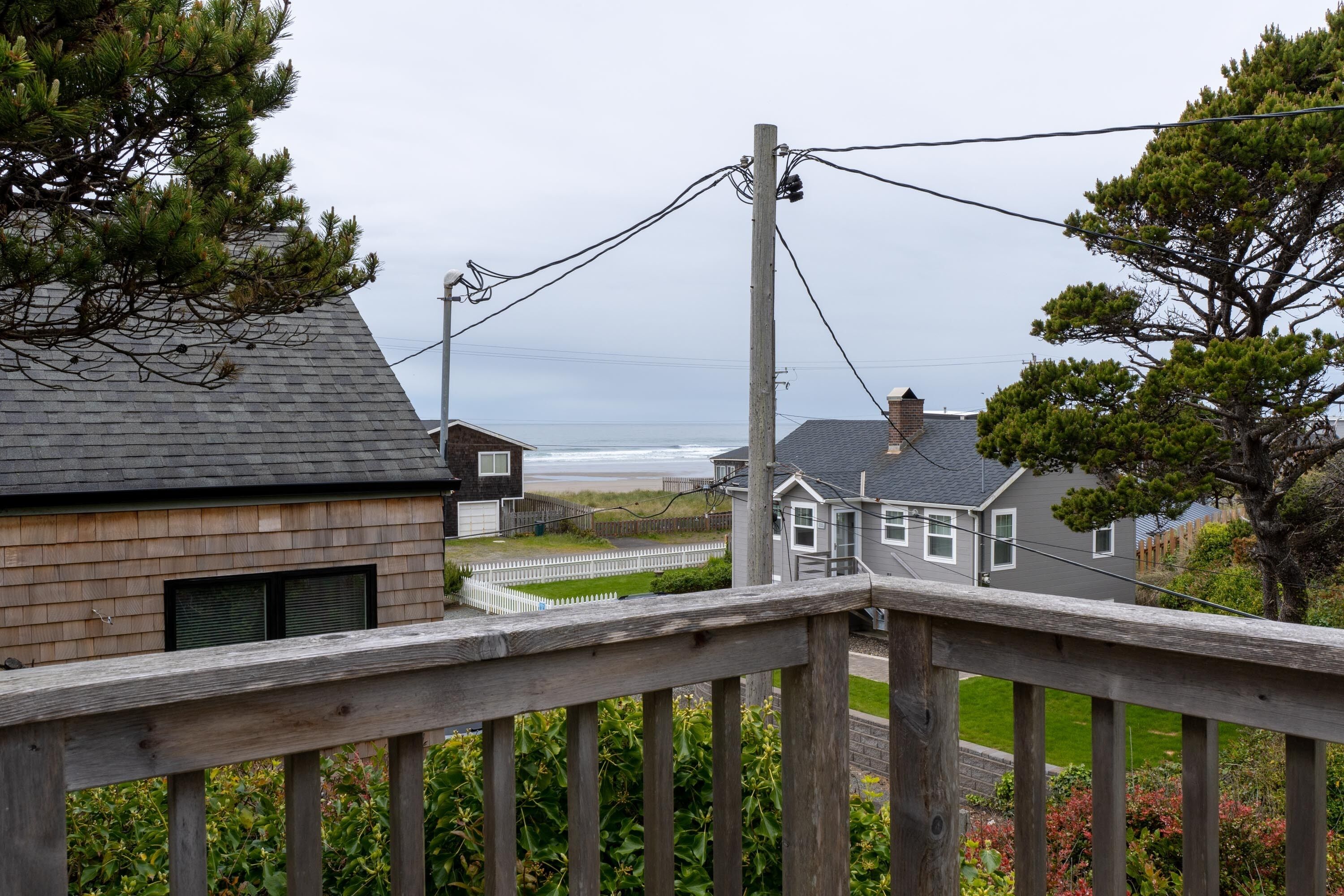 Un quartier résidentiel avec des maisons, une terrasse en bois et une vue sur l’océan.