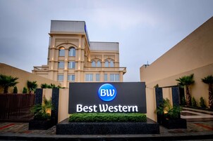 Entrada de un hotel con un cartel que dice "Best Western" y una fachada de edificio moderna.
