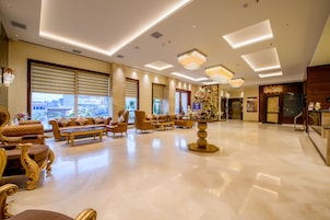 Un vestíbulo amplio con piso de mármol pulido, muebles elegantes e iluminación moderna.