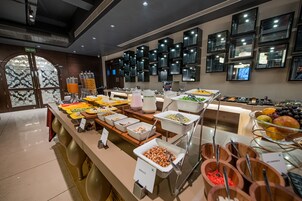 Un bufé con diferentes opciones de comida y un letrero de salida de incendios.