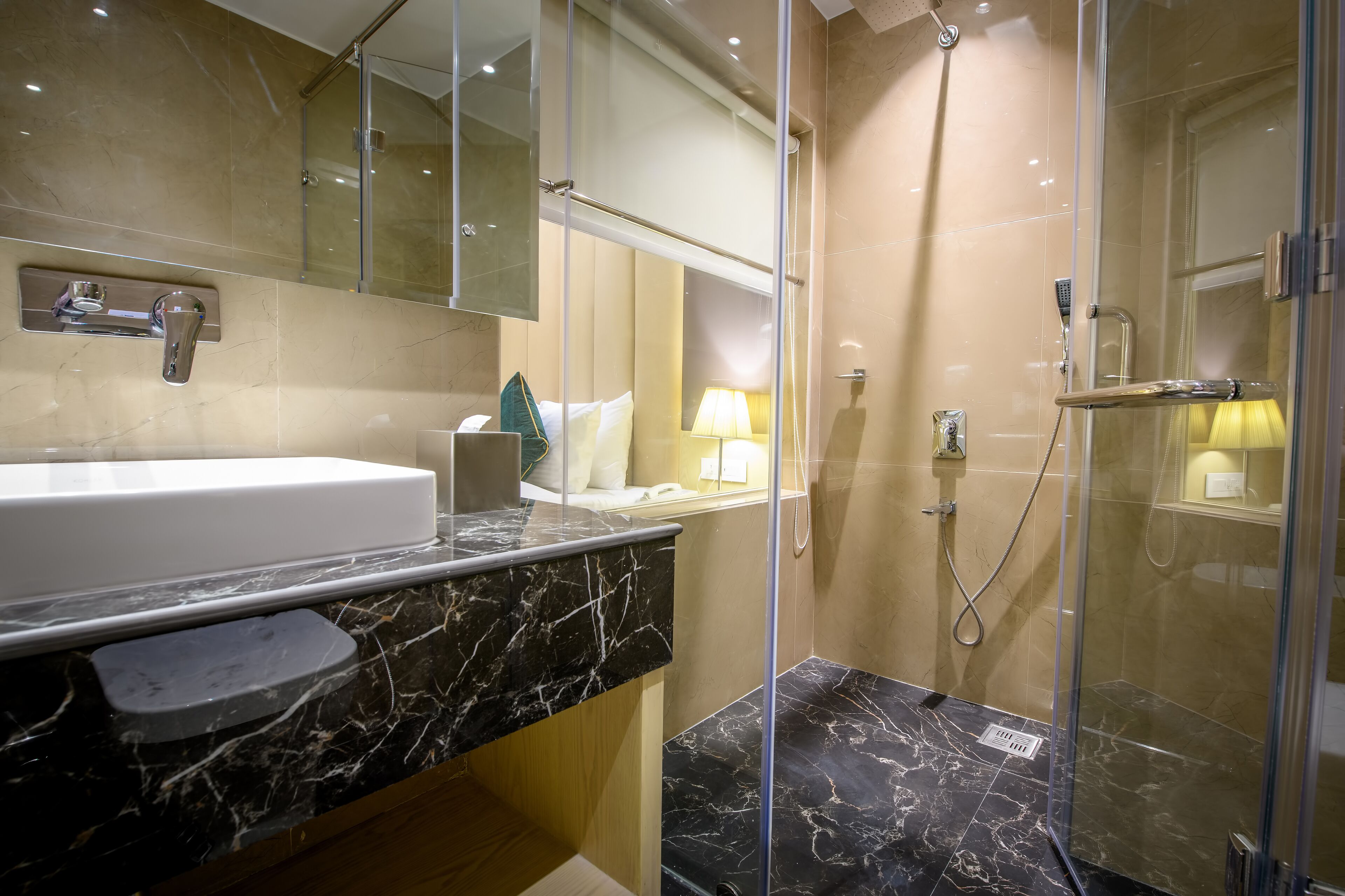 A modern bathroom with a marble sink, a glass-enclosed shower, and a large mirror.