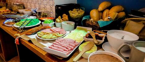 A buffet table with various dishes including meats, vegetables, and desserts.