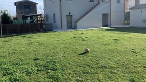 Uma casa moderna de dois andares com um gramado bem cuidado e uma antena parabólica visível.