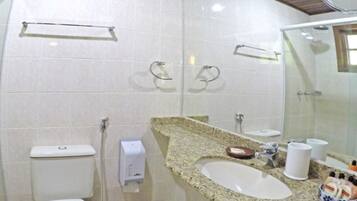 A bathroom with a toilet, sink, and shower.
