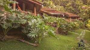 Una hilera de edificios de estilo tradicional con tejados de tejas, rodeados de abundante vegetación y un césped cuidado.