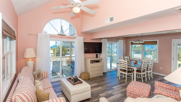 A spacious living area with a sofa, ottoman, and dining table. - Sea K's - 3 bedroom, 2 bath home in Topsail Beach!  Dog Friendly! (Topsail Beach)