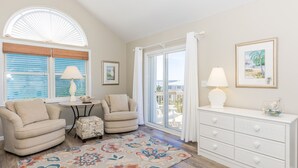A living room with two armchairs, a small table, a white dresser, and a colorful rug. - Sea K's - 3 bedroom, 2 bath home in Topsail Beach!  Dog Friendly! (Topsail Beach)