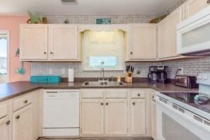A kitchen with light wood cabinets, a white dishwasher, a double sink, and a microwave. - Sea K's - 3 bedroom, 2 bath home in Topsail Beach! Dog Friendly! (Topsail Beach)
