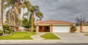 A single-story house with a red-tiled roof, a front garage, and a well-maintained lawn.