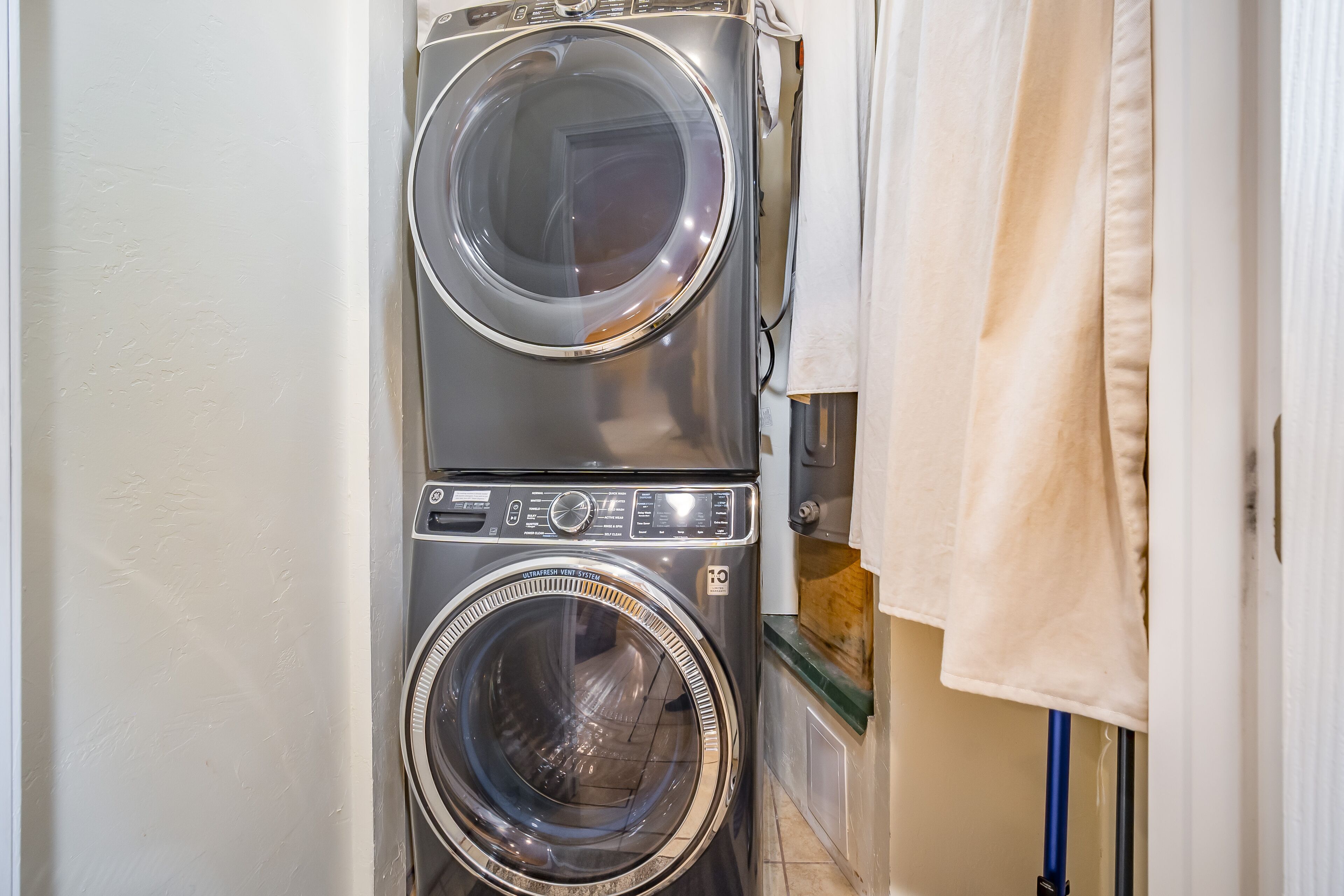 Une machine à laver et un sèche-linge superposés dans une buanderie.